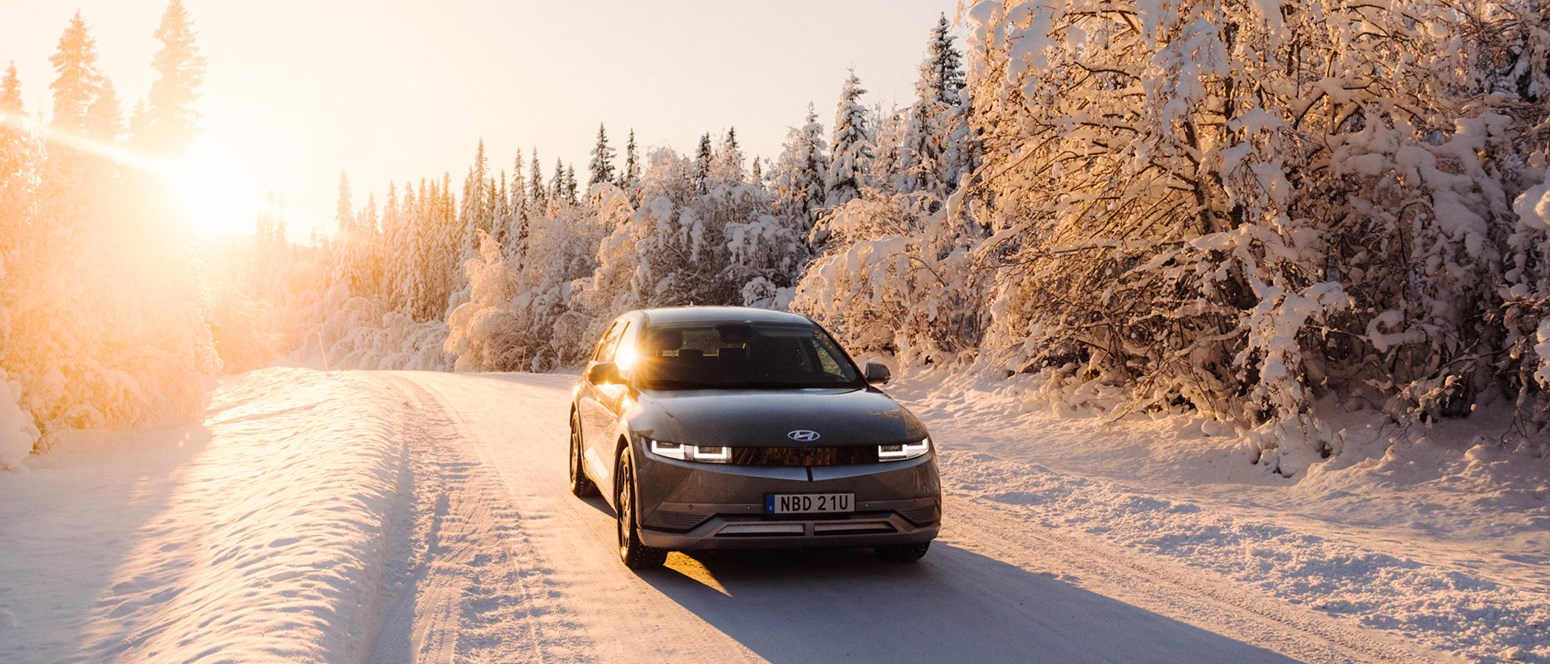 Tips på sportlovsutflykter i Åre - Hyundai IONIQ 5 i motljus i ett snötäckt vinterlandskap.