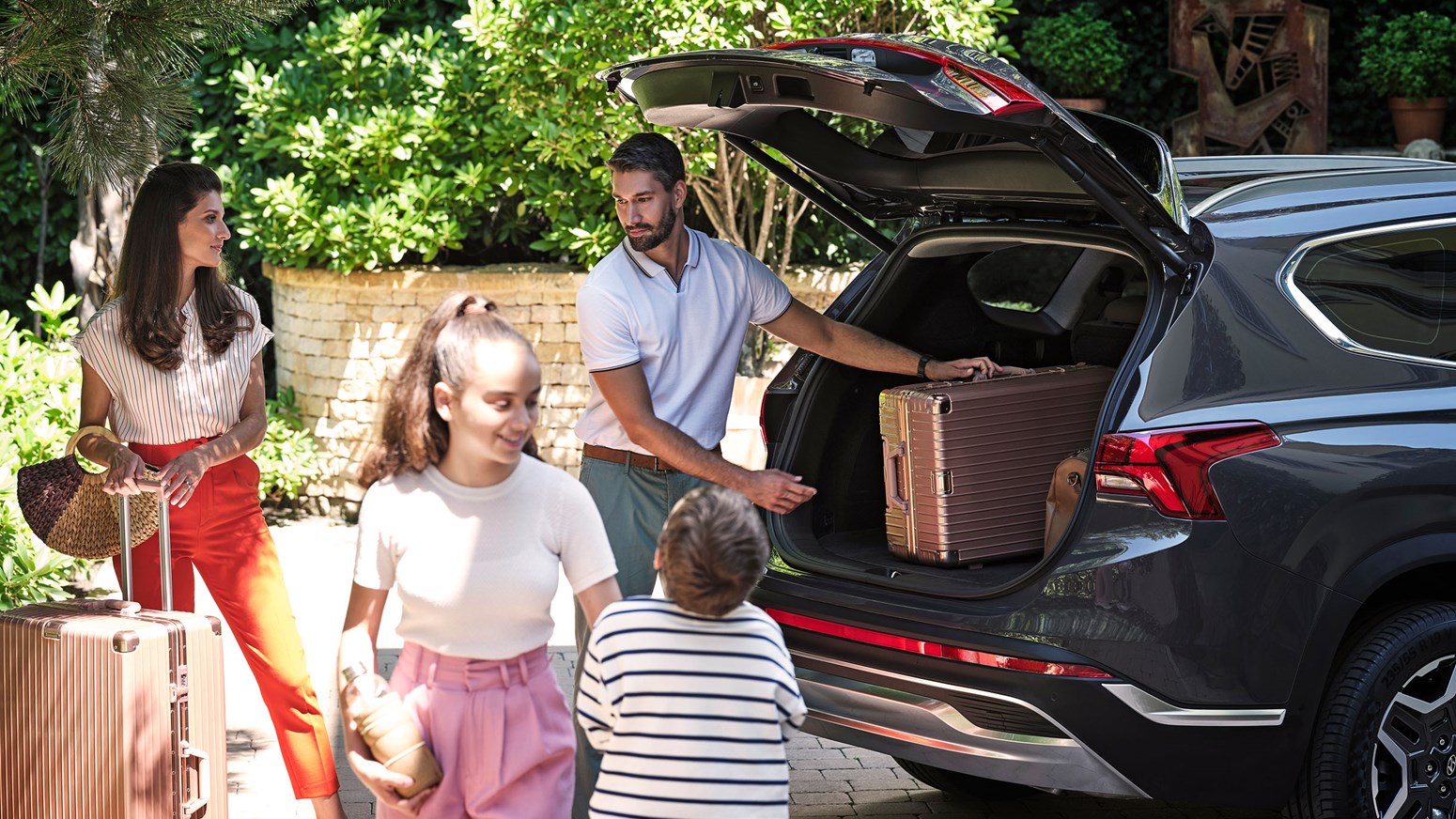Bildgalleri - En familj lastar in väskor i en Hyundai SANTA FE Hybrid.