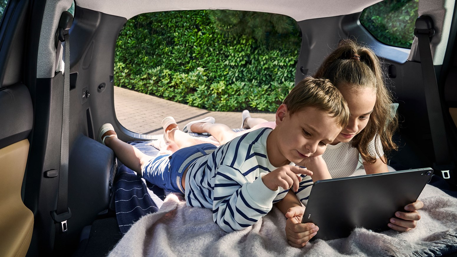 Bildgalleri - Två barn ligger i bagageutrymmet på Hyundai SANTA FE Hybrid.
